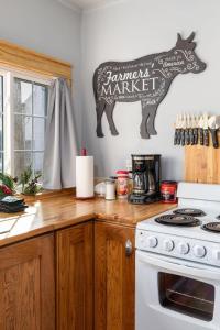 eine Küche mit einem Kuhschild an der Wand in der Unterkunft Historic Rockaway Beach Cottage in Rockaway Beach + 6 Fotos