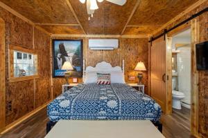 ein Schlafzimmer mit einem Bett in einem Zimmer mit Holzwänden in der Unterkunft Historic Rockaway Beach Cottage in Rockaway Beach