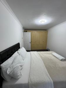 ThamesmeadにあるThamesNicePropertyの白いシーツが敷かれた大きなベッドのある寝室