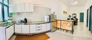 a kitchen with white cabinets and a refrigerator at Fnaa Tg Bidara Malacca Guest House - 3BR Fully Aircond in Masjid Tanah