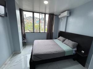 a small bedroom with a bed and a window at Scotland Hotel in Guayaquil