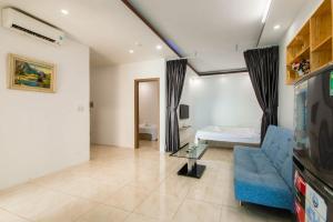 a living room with a blue couch and a bed at Oceanus MT Vien Trieu Thai Ha Hotel & Apartment in Nha Trang