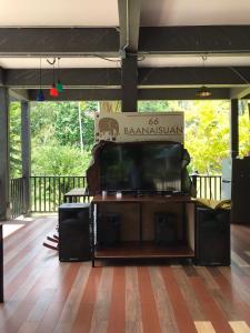 Un televisor de pantalla plana grande colocado encima de una terraza. en 66 Baanaisuan 66 บ้านในสวน, en Ban Komo Sam Sip Paet