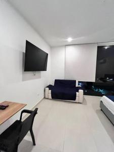 ein Wohnzimmer mit Sofa und Fernseher in der Unterkunft Apartamento con vista al mar Santa Marta Colombia in Playa Bello Horizonte