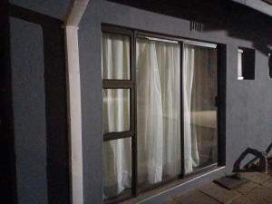 a window with white curtains in a room at Single room for 1 in Vereeniging