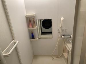a bathroom with a microwave on the wall at 【509号室】小樽キャナルビュー AMS海宝樓 in Kita-hamachō