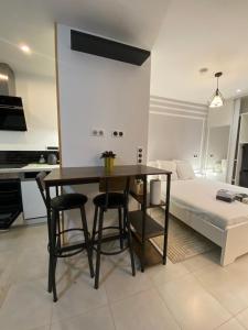 a kitchen and dining room with a table and a bed at La romance 19 in Maintenon