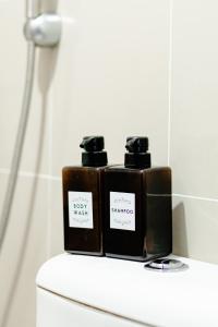 two bottles of soap sitting on top of a toilet at Cubao Manhattan Heights Residential Condo TB30N - High Floor Studio with Balcony City View, Pool, Netflix, 5-Min Walk to the Araneta Coliseum Gateway Mall SM - Staycations by SMS in Manila