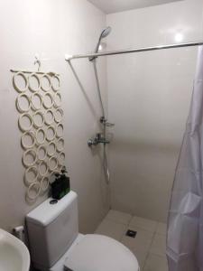a white bathroom with a toilet and a shower at Cubao Manhattan Heights Residential Condo TB30N - High Floor Studio with Balcony City View, Pool, Netflix, 5-Min Walk to the Araneta Coliseum Gateway Mall SM - Staycations by SMS in Manila
