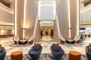a lobby with couches and chairs in a building at Sheraton Mall of the Emirates Hotel, Dubai in Dubai