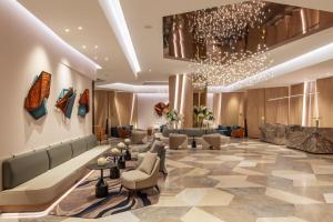 a lobby of a hotel with couches and chairs at Sheraton Mall of the Emirates Hotel, Dubai in Dubai