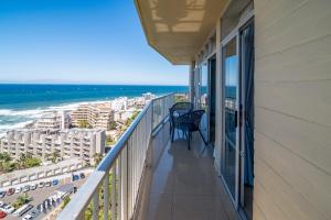 a balcony with two chairs looking out at the ocean at Coastal View @ 1304 La Ballito in Ballito