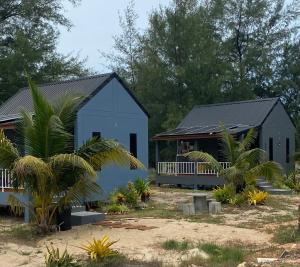 a blue building with a porch and a house at 4U Resort & Camp in Ban Kampong Ba-Ru