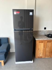 una nevera negra en una cocina con encimera en Paddy's House Seseh, en Canggu