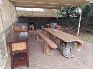 a group of wooden tables and stools under a tent at Pakenham Central in Echuca