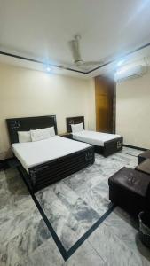 Cette chambre comprend deux lits. dans l'établissement New Palace Guest House, à Islamabad