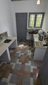 a room with a kitchen with a sink and a door at Green Pearls Stay in Santhanpara