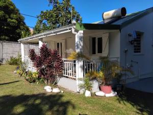 a white house with plants in the yard at Maison verte in Capesterre-Belle-Eau