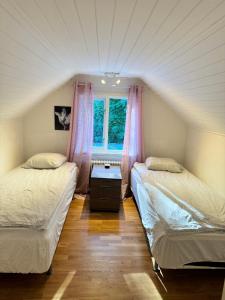 twee bedden in een kamer met een raam bij Beutiful house with large garden . in Lilla Edet