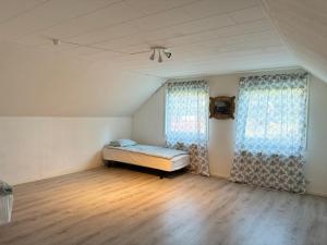 een lege kamer met een bed en twee ramen bij Beutiful house with large garden . in Lilla Edet