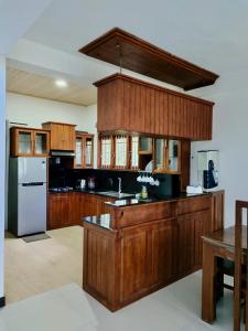 a large kitchen with wooden cabinets and a refrigerator at ECO Canal Suite in Polonnaruwa