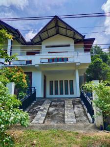 a white house with a pathway in front of it at ECO Canal Suite in Polonnaruwa