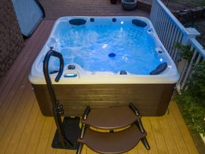 bañera de hidromasaje en una terraza con silla en Yosemite Creekside Retreat with spa/games/EV Charger and more, en Yosemite Forks