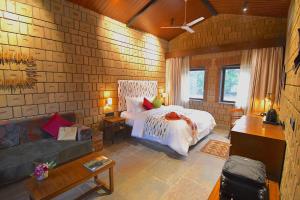 a bedroom with a bed in a brick wall at Arbor Road Estate in Pāmalparti
