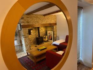 a room with a living room with a mirror at Cotswold Cottage in Steeple Aston