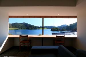 a room with a large window with a view of a lake at HEKISUIEN in Minatomiya