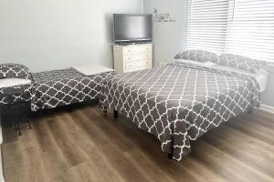 1 Schlafzimmer mit 2 Betten, einem TV und Holzböden in der Unterkunft Stone Mountain's Hidden Secret in Stone Mountain