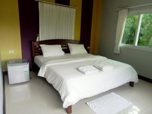 two beds in a bedroom with two towels on them at Kanda Hill Resort in Ban Na Sok