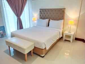 a bedroom with a large white bed and a chair at โรงแรมอินจัน Inn-Chan in Chanthaburi