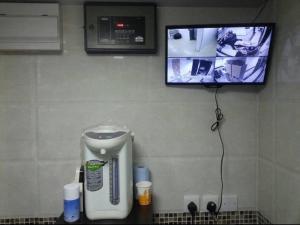 TV en la pared de un baño con secador de pelo en New Euro Asia Guest House, en Hong Kong