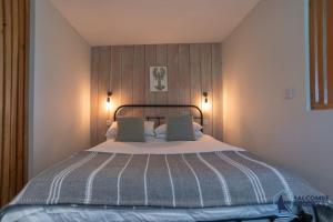 a large bed in a room with two pillows at The Hideout-Boutique Cabin, Estuary View & Parking in Salcombe