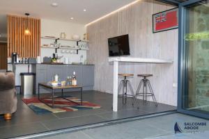 a kitchen with a counter and stools in a room at The Hideout-Boutique Cabin, Estuary View & Parking in Salcombe