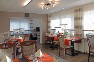 a dining room with tables and chairs in a restaurant at Pension Haus Waldfrieden, MeineCardPlus inklusive in Willingen