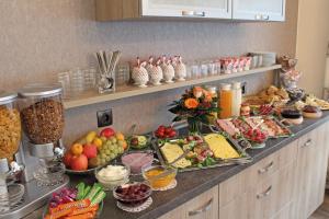 un buffet con muchos tipos diferentes de comida en una barra en Pension Haus Waldfrieden, MeineCardPlus inklusive, en Willingen