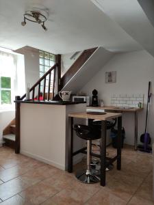 une cuisine avec un comptoir et une table avec des chaises dans l'établissement Le cottage de Mercey, à Mercey