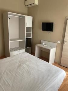 a bedroom with a bed and a desk and a tv at Piccolo Hotel in Rosignano Solvay