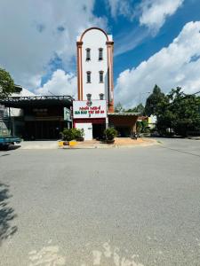 un bâtiment avec une tour d'horloge sur le côté d'une rue dans l'établissement GIA BẢO TÂY ĐÔ 3 Hotel, à Ấp Bình Thương