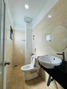 une salle de bain avec toilettes, lavabo et miroir dans l'établissement GIA BẢO TÂY ĐÔ 3 Hotel, à Ấp Bình Thương