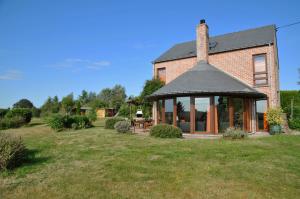 a brick house with a gazebo in a yard at Rotonde in Somme-Leuze