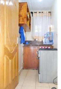 Una pequeña cocina con fregadero y refrigerador. en Nanasi Homes, en Thika