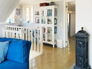 a living room with a blue couch and a book shelf at 4 star holiday home in KYRKESUND in Kyrkesund