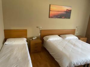 a bedroom with two beds and a telephone in it at Piccolo Hotel in Rosignano Solvay