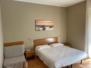 a bedroom with a bed and a nightstand and a bed sidx sidx sidx sidx at Piccolo Hotel in Rosignano Solvay