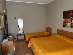 a hotel room with two beds and a mirror at Piccolo Hotel in Rosignano Solvay