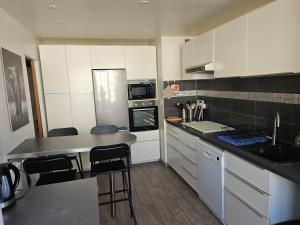 une cuisine avec des armoires blanches et un comptoir dans l'établissement Spacieux appartement 90m2 4 chambres, proche mer, climatisation, tout confort, à Toulon