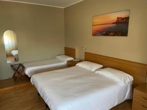 a hotel room with two beds and a picture on the wall at Piccolo Hotel in Rosignano Solvay +38 photos